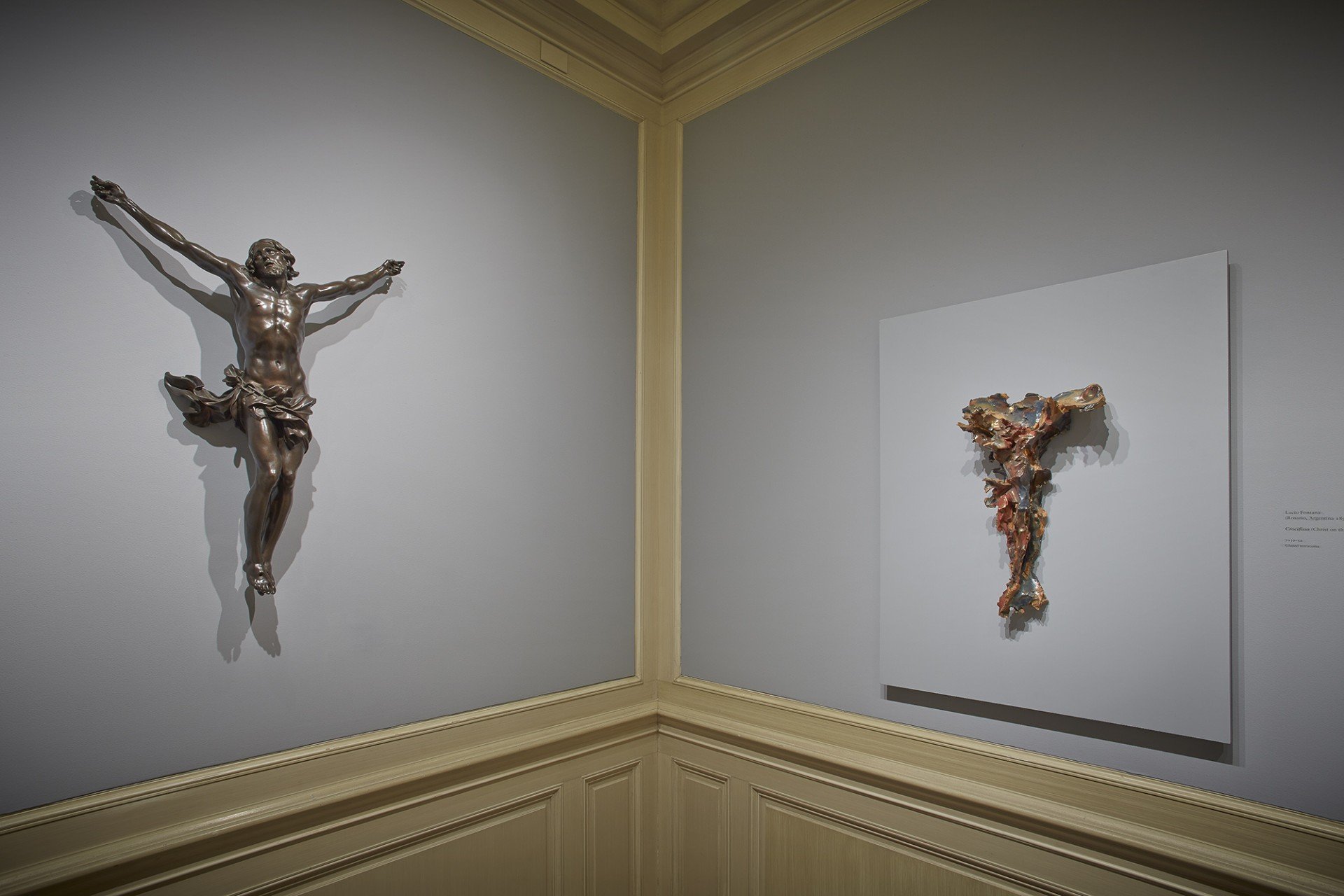 Installation view showing a pairing in the Frick's Cabinet gallery: Alessandro Algardi's Cristo Vivo (“The Living Christ on the Cross”), juxtaposed with Lucio Fontana's Crocifisso (“Christ on the Cross”), © Fondazione Lucio Fontana, Milan; photo: Michael Bodycomb