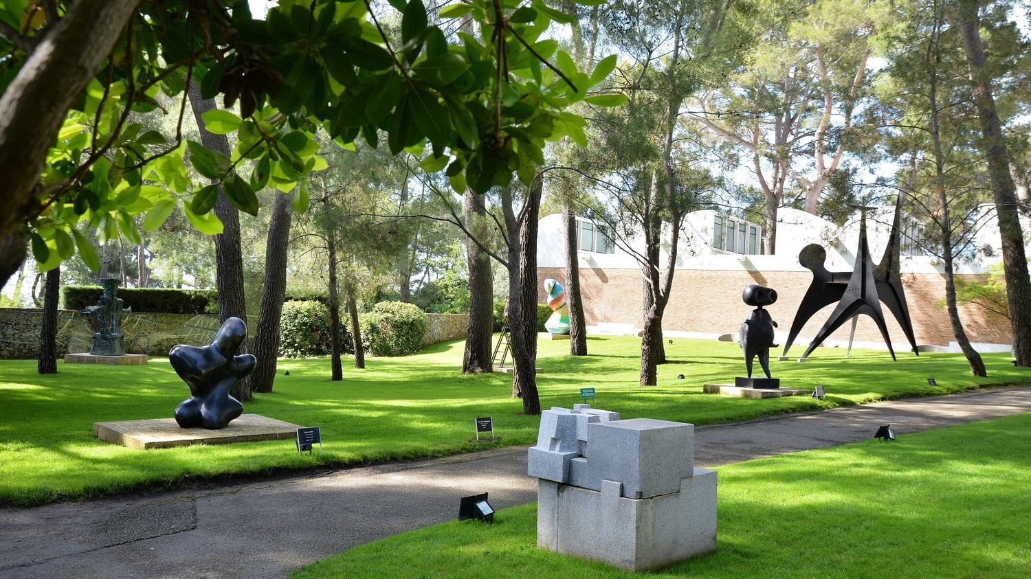 Le jardin de sculptures : œuvres d’Eduardo Chillida, Iru Burni, 1968 – 1969, Jean Arp, Le pépin géant, 1937-1957, Joan Miró, Personnage, 1970, Alexander Calder, Les renforts, 1963. Ph. Roland Michaud / Archives Fondation Maeght