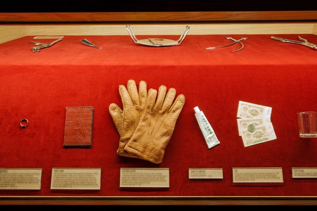 a museum display with some gloves, hand cream, the red book from the communist party