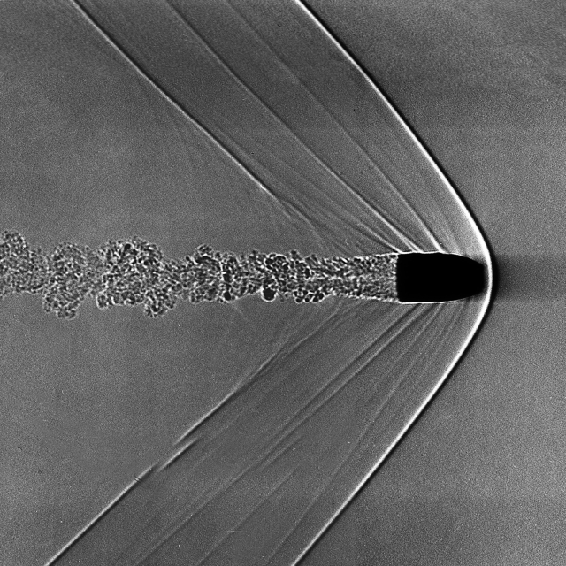 “Supersonic Bullet Shadowgraph”Image of a supersonic bullet created using a Shadowgraph. The V-shaped shockwaves are clearly visible; propagating from the front-most tip of the bullet is the